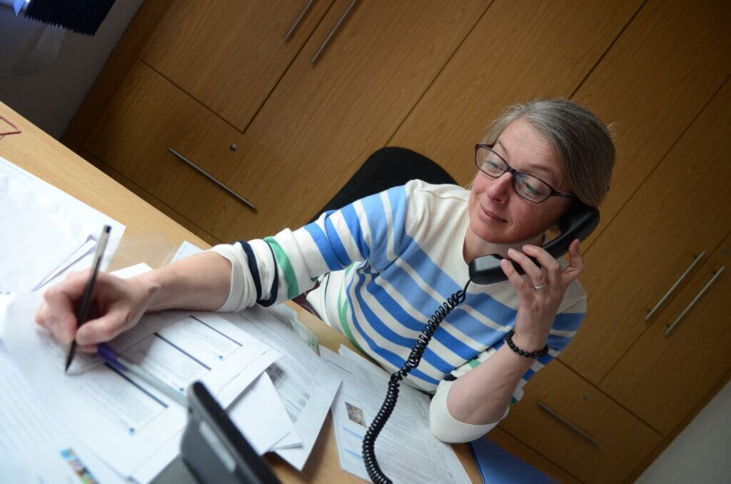 A woman on the telephone in the office.