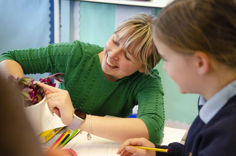 Teacher showing pupil a plant