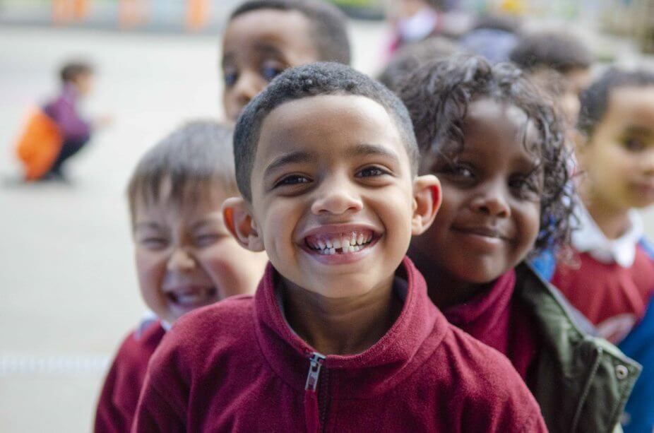 Three young children smiling at the camera.