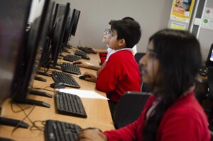 Pupils sitting in front of computers in an ICT classroom.
