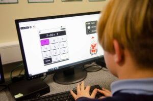 A boy using an online calculator on the computer.