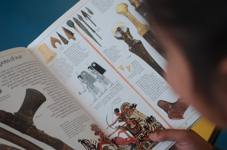 The pages of an ancient history textbook with coloured illustrations.