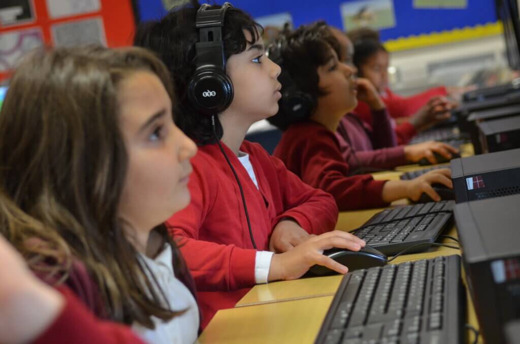pupils study screens in ICT lesson