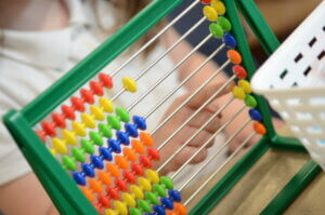 A child pointing at an abacus.