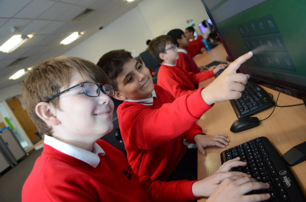 boy pupils helping each other ICT lesson