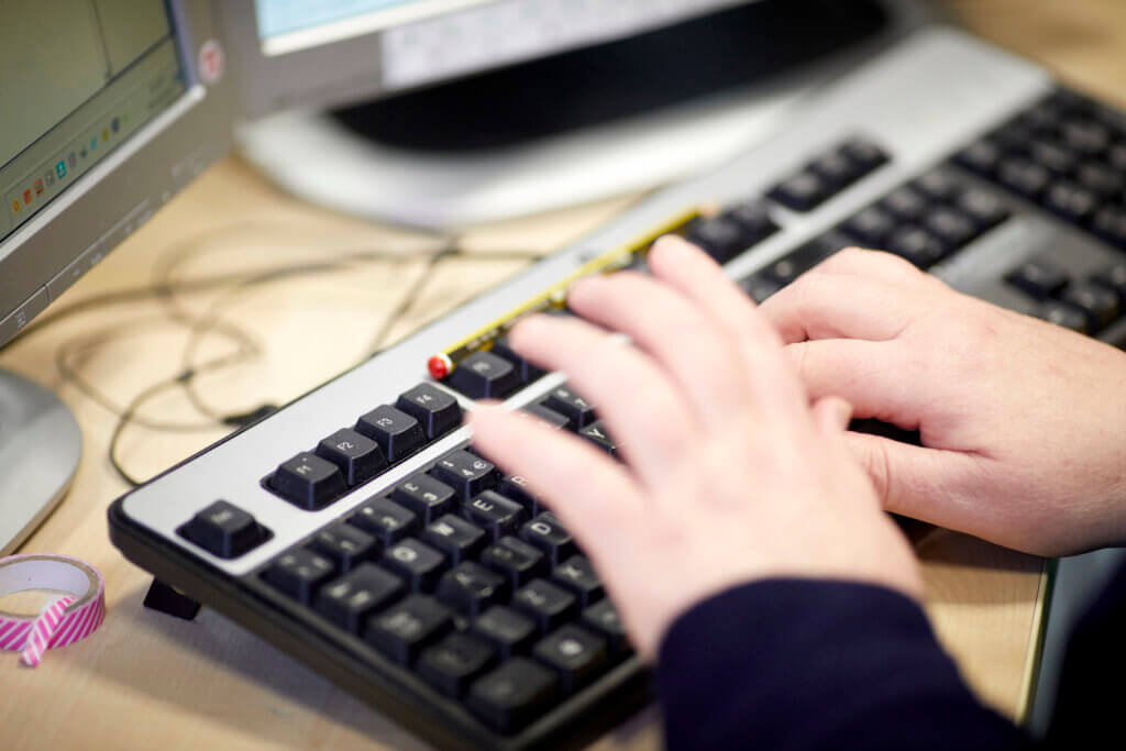 Hands typing on a keyboard.