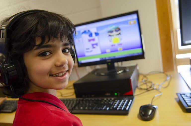 boy pupil smiling at computer ICT lesson