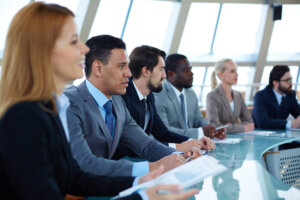 Business professionals sitting around a table in a meeting.