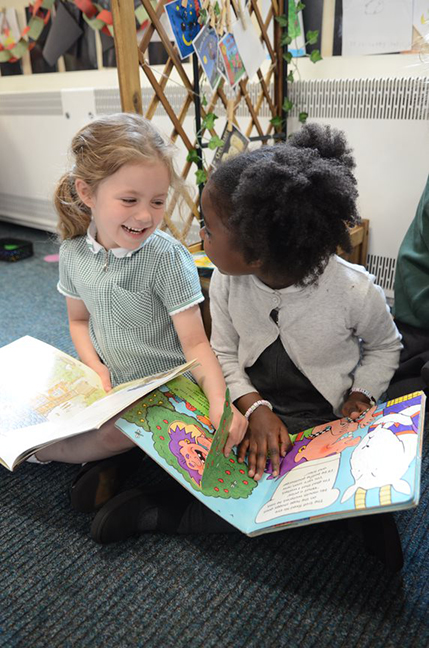 2 girl pupils reading books primary school