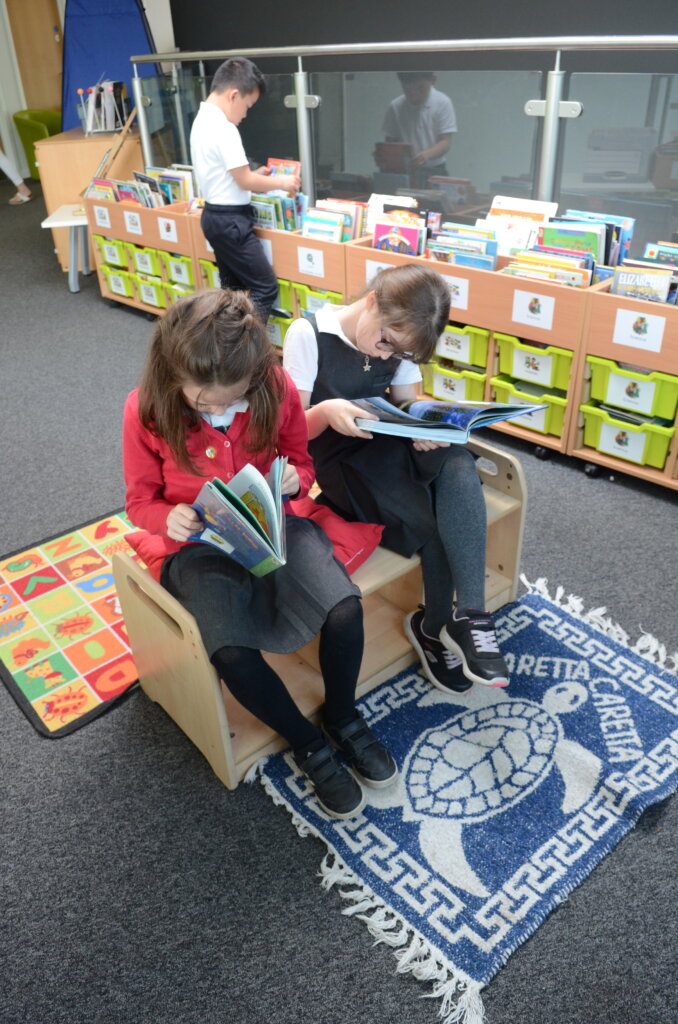 two girl pupils reading books