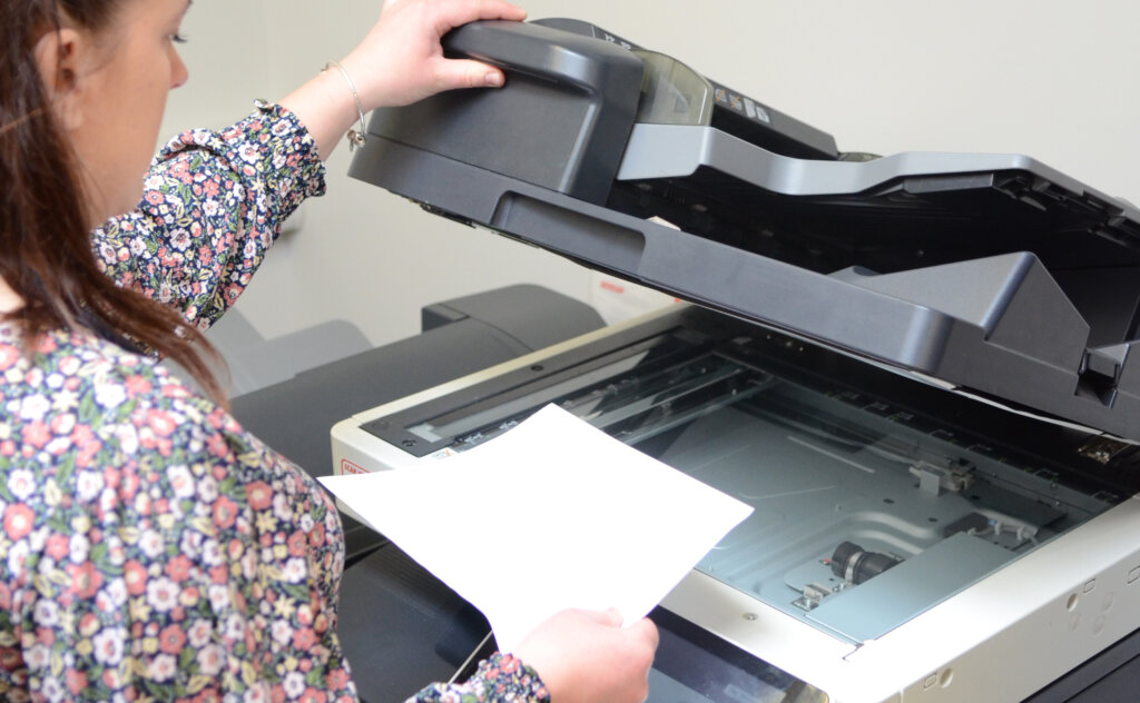 staff member operates a photocopier in a school