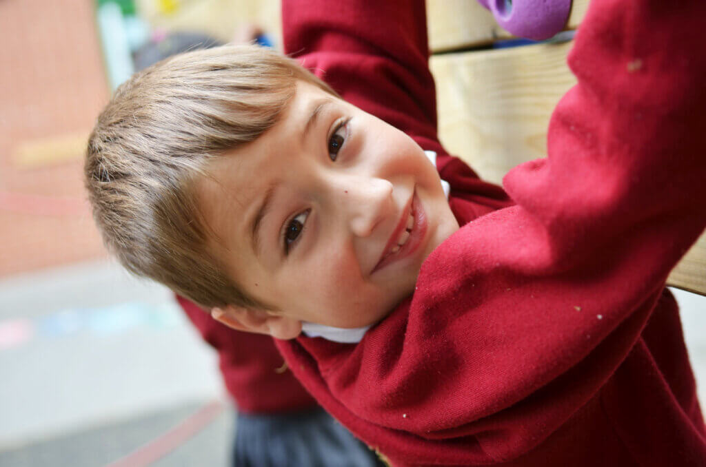 boy smiling climbing frame