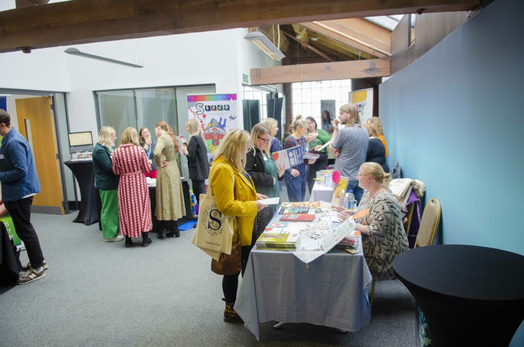 delegates at literacy conference with exhibitors stall