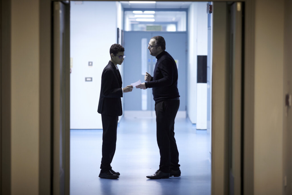 A teacher and student talking together in the school corridor.