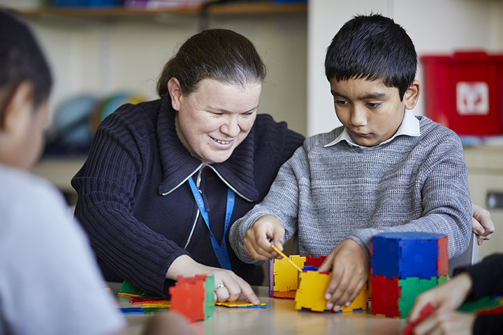 A teacher and pupil playing with Zaks construction toys.
