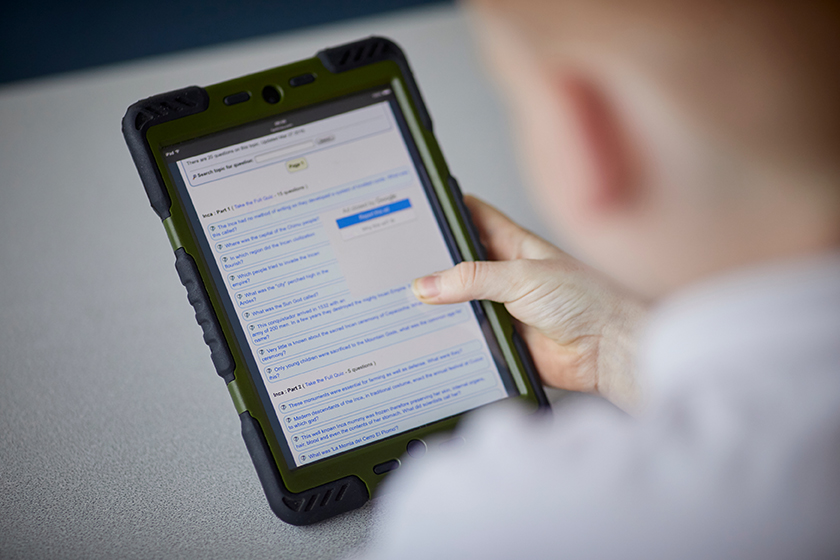 A student holding a digital tablet.