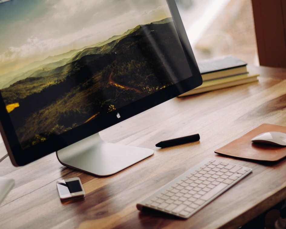 A mac computer with a screensaver showing a natural landscape.