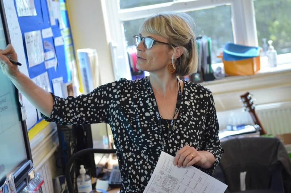 A teacher writing on the interactive white board in the classroom