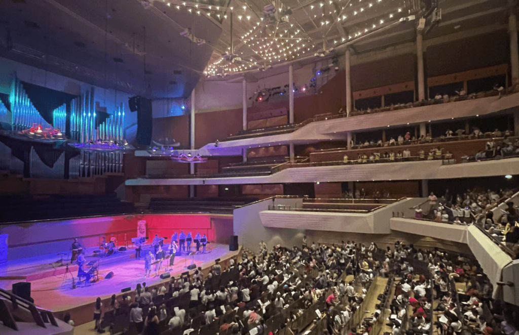 Children sitting in the audience at the Bridgewater Hall, singing along with the band on stage for the Big Sing
