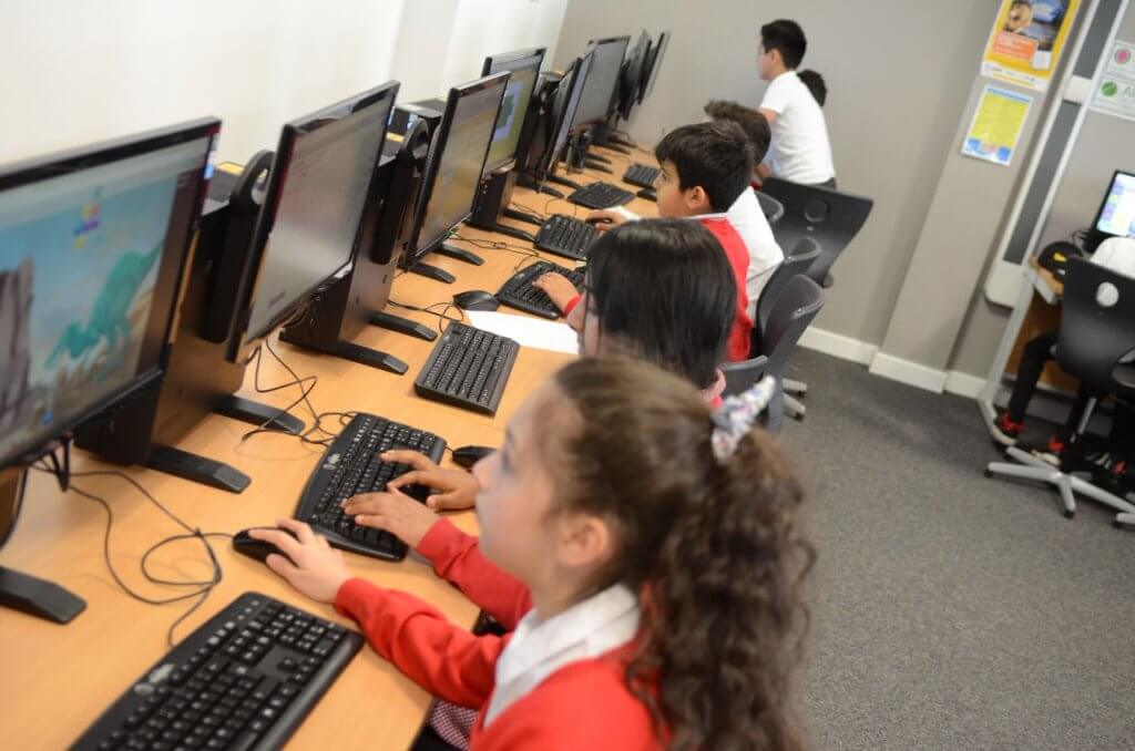School children sitting at computer desks.
