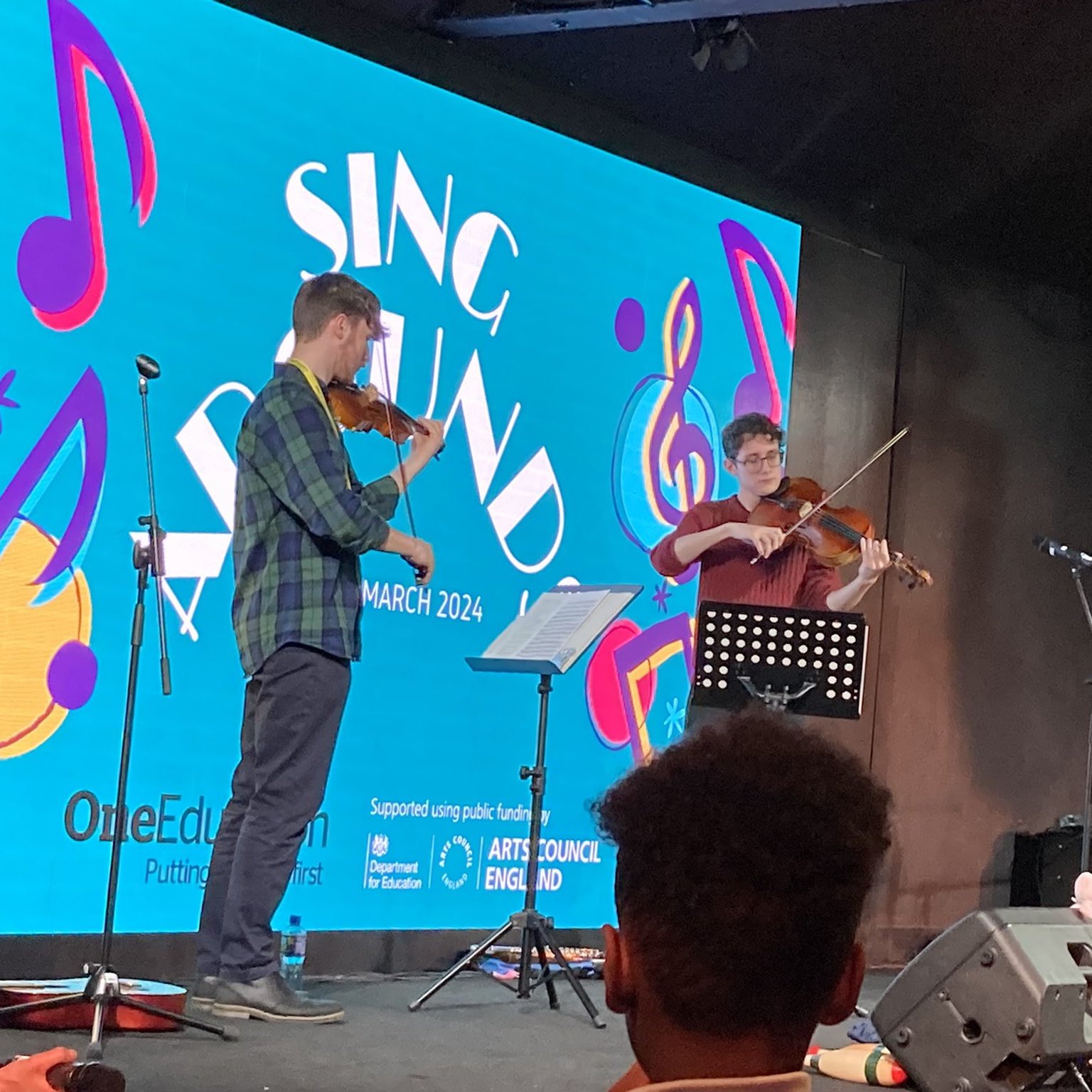Angus and Matthew, students from the Royal Northern College of Music, playing the violin and viola on stage.