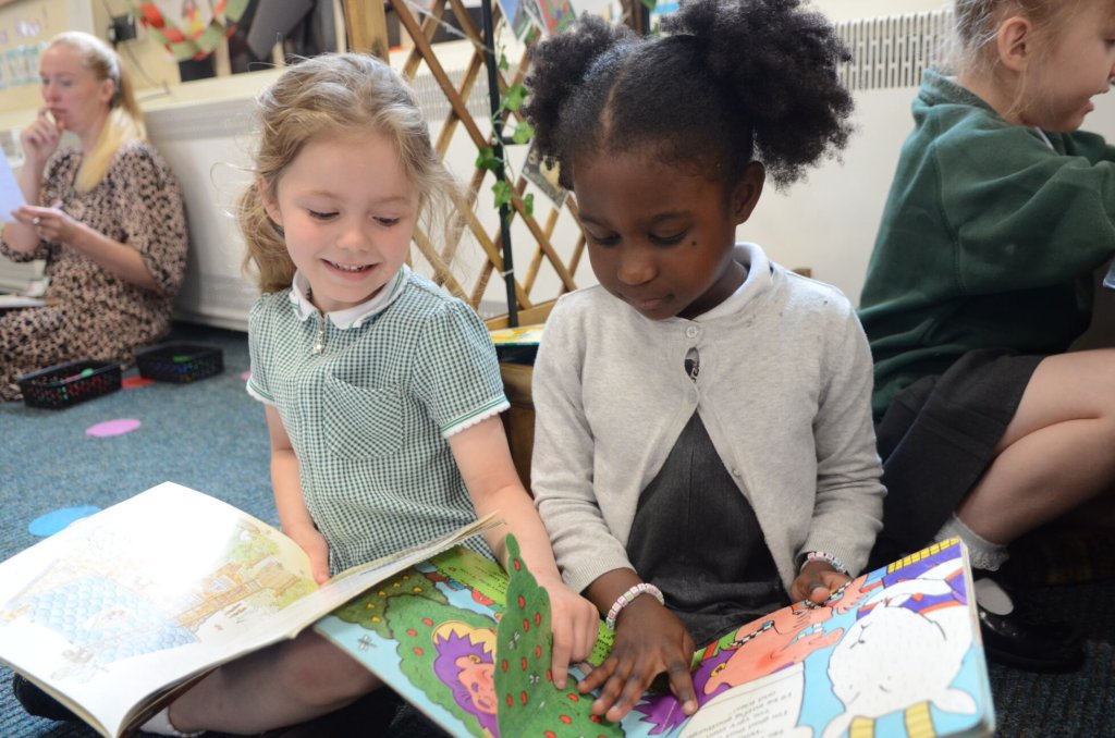 Two girls in Early Years reading books together