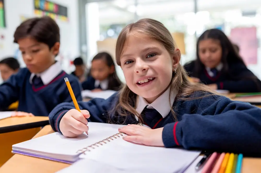 pupil holds pencil white writing