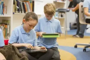 two pupils read on ipads