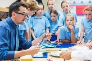 teacher demonstrates to group of pupils