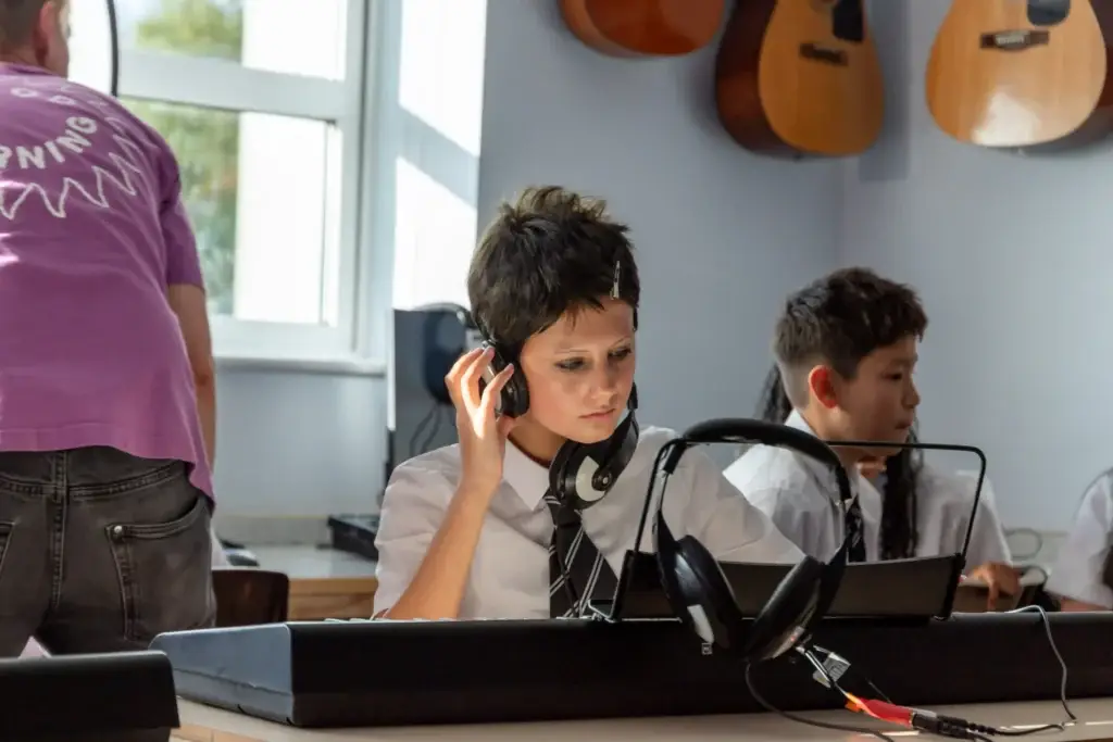 pupil on keyboards and waering headphones