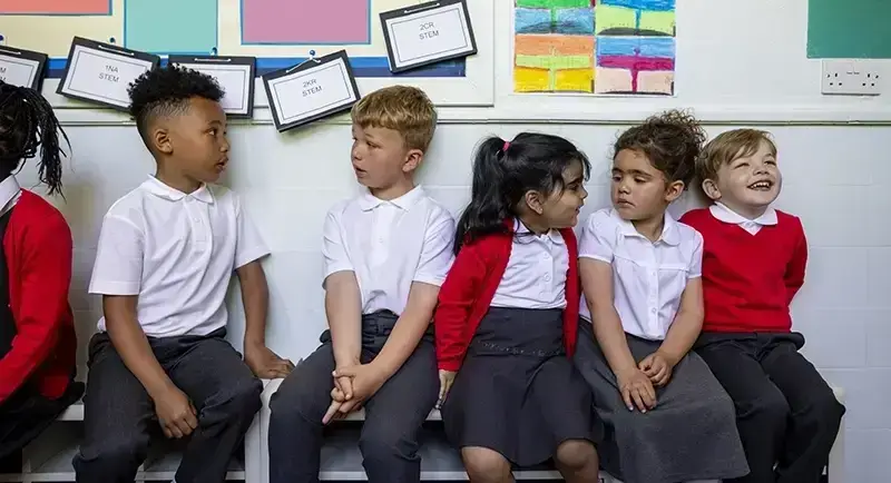 pupils sitting in corridor talking