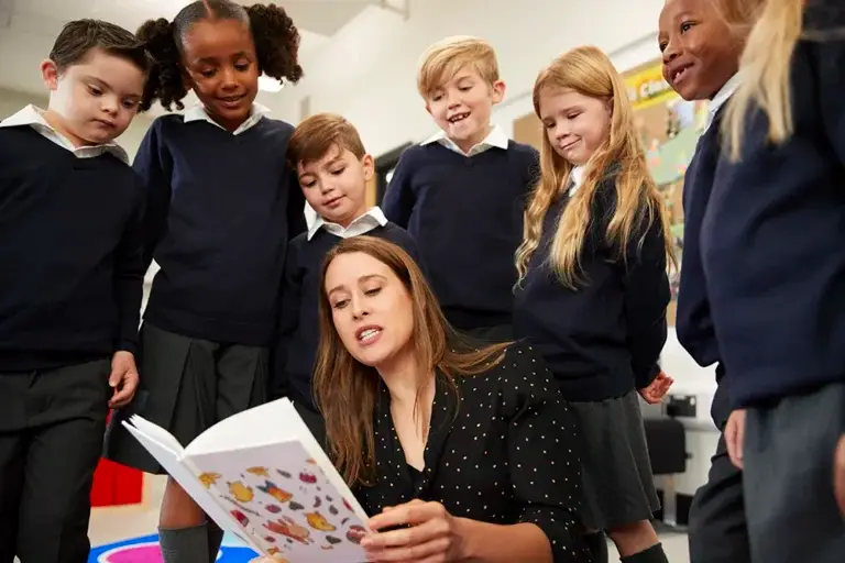 pupils stand around as teacher reads
