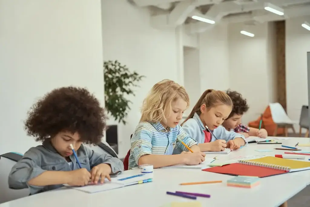 children studying at a white table in classroom 2026 01 09 00 26 58 utc